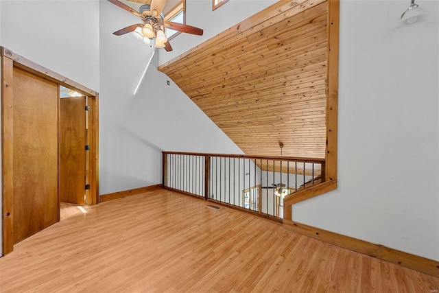 bonus room featuring a ceiling fan, wood finished floors, baseboards, and high vaulted ceiling