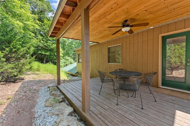 wooden deck with a ceiling fan and outdoor dining space