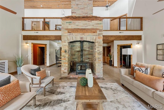 17102 Deer Mountain Rd, Marthasville, MO 63357 - tiled living room with a high ceiling, baseboards, stairs, a wood stove, and wood ceiling