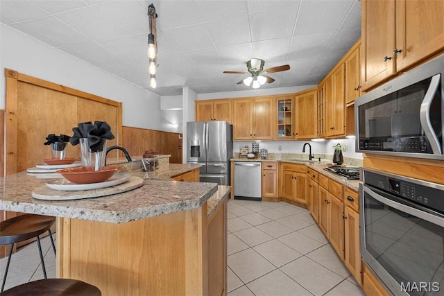 17102 Deer Mountain Rd, Marthasville, MO 63357 - kitchen with appliances with stainless steel finishes, light tile patterned floors, a sink, and a kitchen breakfast bar