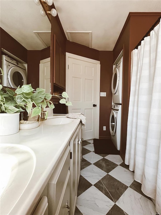 bathroom featuring stacked washer / drying machine and double vanity