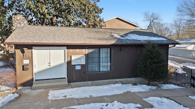 1229 N 17th St Unit 3, Belleville, IL 62226 - snow covered property entrance with a chimney and roof with shingles