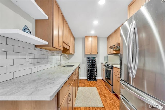 200 S Brentwood Unit 12F, Saint Louis, MO 63105 - kitchen featuring appliances with stainless steel finishes, a sink, light wood finished floors, under cabinet range hood, and tasteful backsplash
