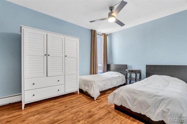 200 S Brentwood Unit 12F, Saint Louis, MO 63105 - bedroom featuring wood finished floors, a baseboard heating unit, and ceiling fan
