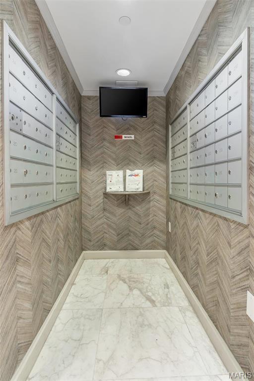 200 S Brentwood Unit 12F, Saint Louis, MO 63105 - surrounding community with mail area, crown molding, recessed lighting, and tile walls