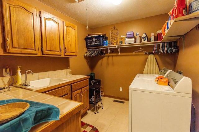 washroom with independent washer and dryer, cabinet space, a textured ceiling, and baseboards