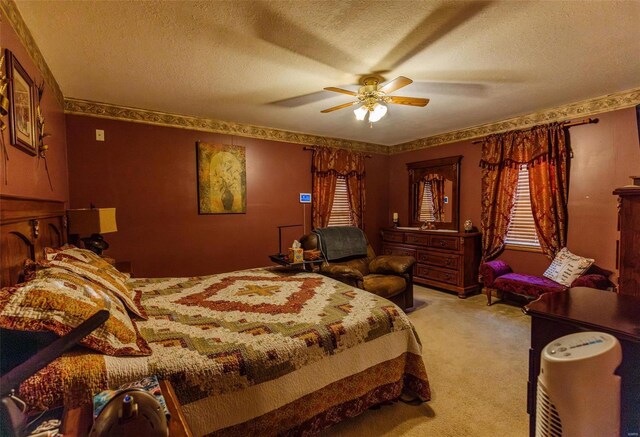 bedroom with a textured ceiling, light colored carpet, and a ceiling fan
