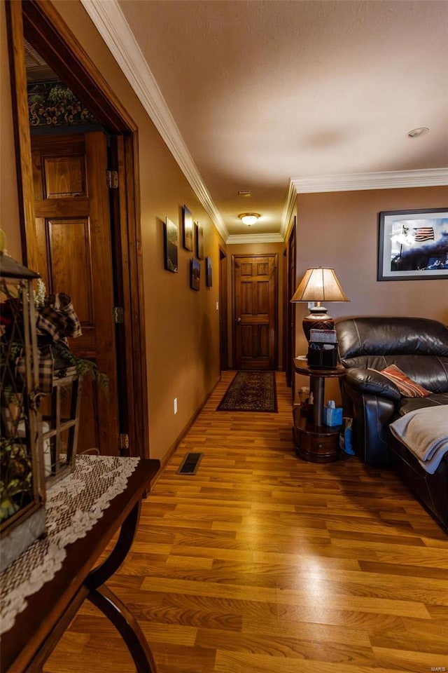 corridor featuring light wood finished floors and crown molding