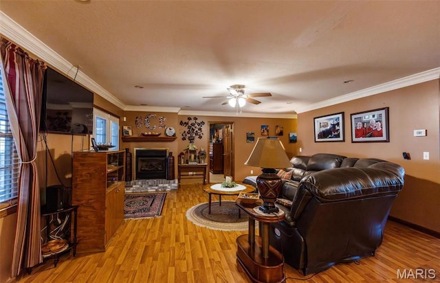 702 S 525th Rd, East Prairie, MO 63845 - living room with wood finished floors, a ceiling fan, a fireplace, and crown molding