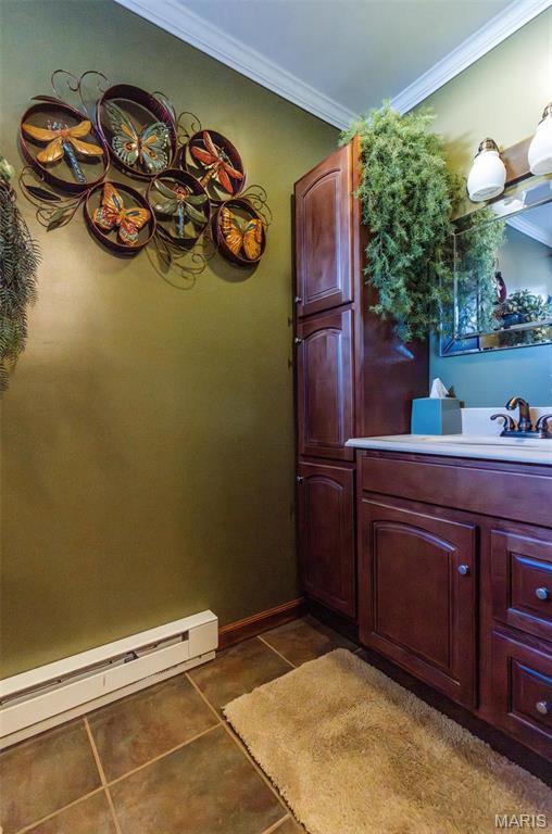 702 S 525th Rd, East Prairie, MO 63845 - bathroom with tile patterned floors, ornamental molding, vanity, a baseboard radiator, and baseboards