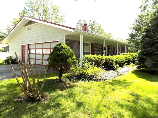 1306 Broadway St, Rolla, MO 65401 - view of side of home with a chimney, a yard, an attached garage, asphalt driveway, and brick siding