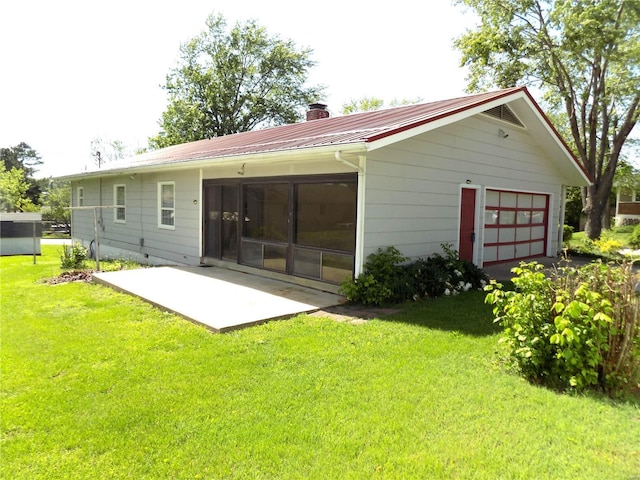 1306 Broadway St, Rolla, MO 65401 - back of house with a chimney, a patio area, a garage, a yard, and metal roof