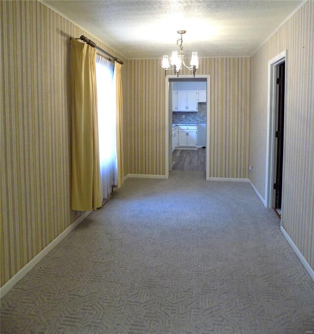 1306 Broadway St, Rolla, MO 65401 - empty room featuring wallpapered walls, a chandelier, ornamental molding, baseboards, and light carpet