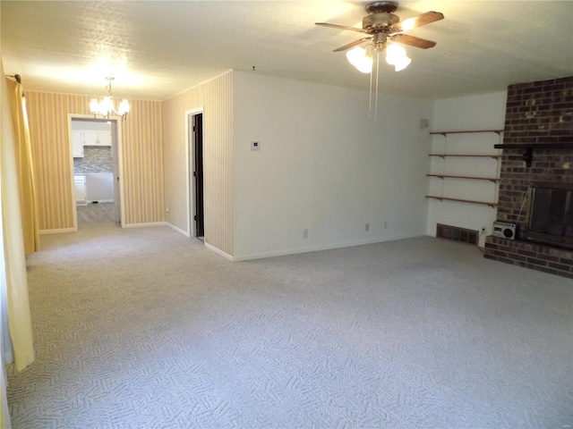1306 Broadway St, Rolla, MO 65401 - unfurnished living room featuring a chandelier, ceiling fan, carpet flooring, and a brick fireplace