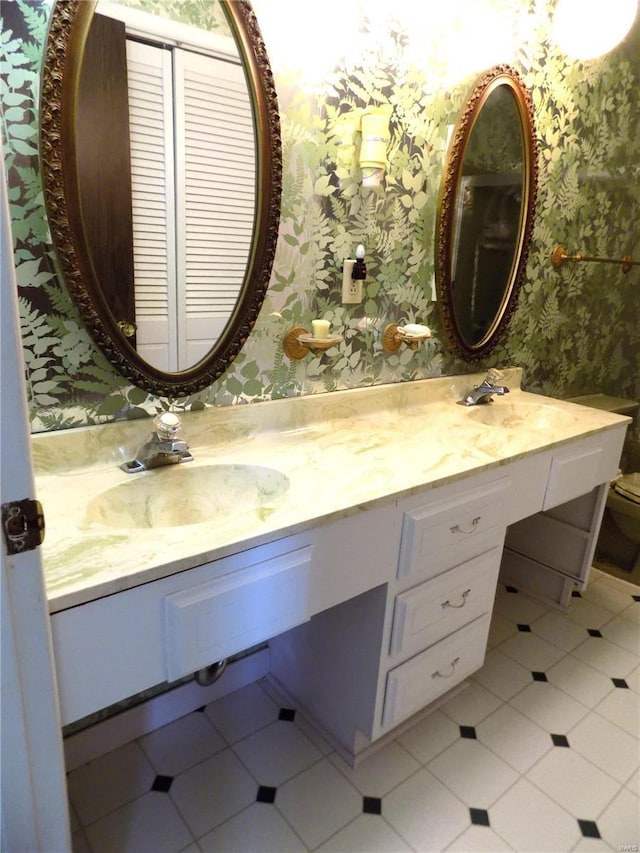 1306 Broadway St, Rolla, MO 65401 - full bath with wallpapered walls, double vanity, tile patterned flooring, and toilet