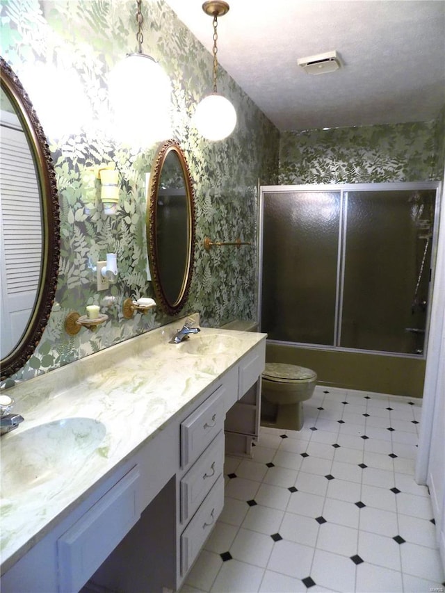 1306 Broadway St, Rolla, MO 65401 - bathroom with wallpapered walls, combined bath / shower with glass door, toilet, and double vanity