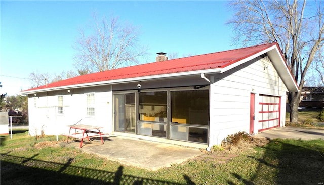1306 Broadway St, Rolla, MO 65401 - rear view of property with a chimney, metal roof, a garage, and a sunroom