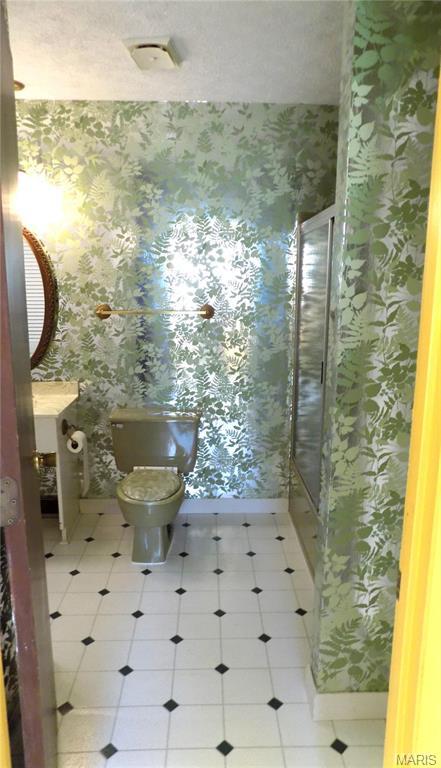 1306 Broadway St, Rolla, MO 65401 - full bath with wallpapered walls, toilet, a shower stall, vanity, and baseboards