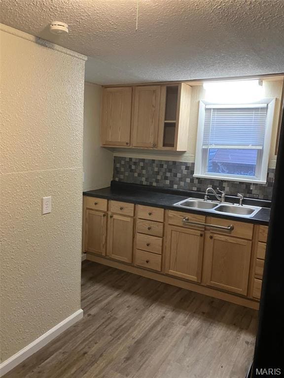 708 E Pear Ave, Owensville, MO 65066 - kitchen featuring a sink, a textured wall, a textured ceiling, dark wood-style floors, and tasteful backsplash
