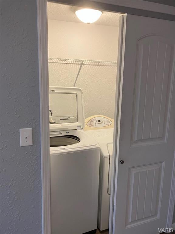 708 E Pear Ave, Owensville, MO 65066 - clothes washing area with washing machine and clothes dryer and a textured wall