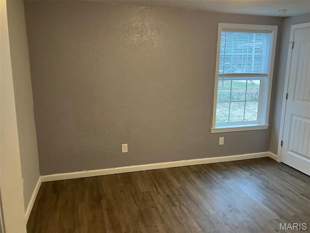 708 E Pear Ave, Owensville, MO 65066 - unfurnished room with dark wood finished floors, baseboards, and a textured wall