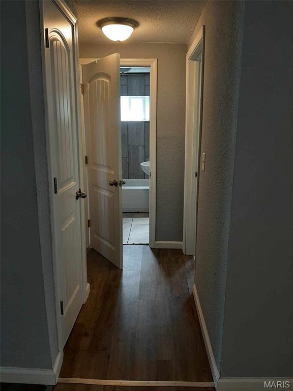 708 E Pear Ave, Owensville, MO 65066 - corridor with wood finished floors, baseboards, a textured ceiling, and a textured wall