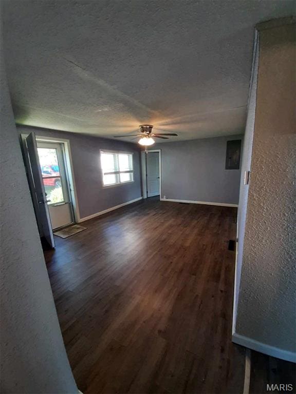 708 E Pear Ave, Owensville, MO 65066 - empty room with dark wood-type flooring, a textured wall, baseboards, a ceiling fan, and a textured ceiling