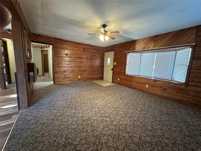 4117 State Highway 21, Grandin, MO 63943 - carpeted empty room with a ceiling fan, wood walls, and a textured ceiling