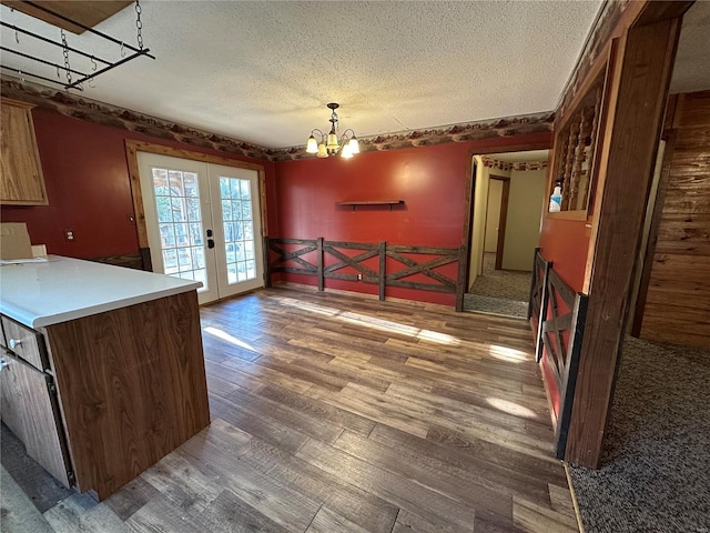 4117 State Highway 21, Grandin, MO 63943 - kitchen with a textured ceiling, french doors, a chandelier, wood finished floors, and a wainscoted wall