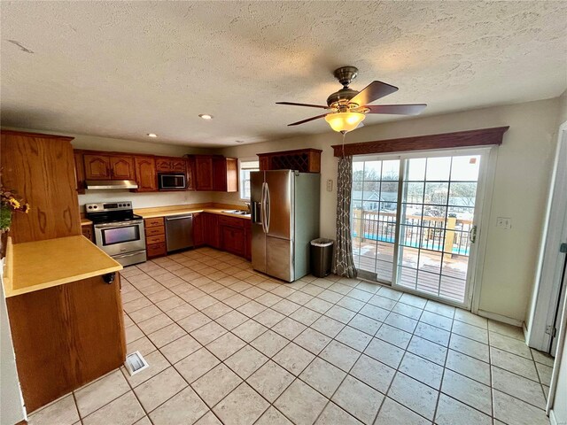 502 Mcclaren Way, Dixon, MO 65459 - kitchen with stainless steel appliances, under cabinet range hood, light countertops, plenty of natural light, and a textured ceiling