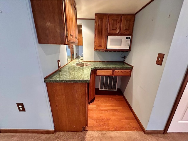 502 Mcclaren Way, Dixon, MO 65459 - kitchen featuring white microwave, a sink, dark countertops, baseboards, and brown cabinets