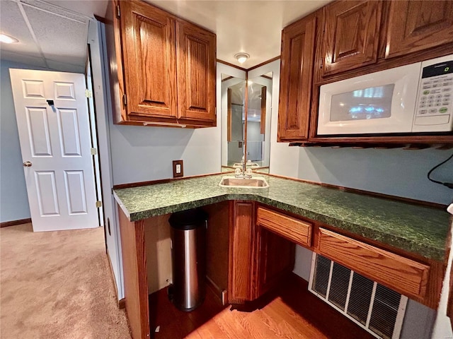 502 Mcclaren Way, Dixon, MO 65459 - kitchen featuring white microwave, brown cabinetry, dark countertops, and a sink