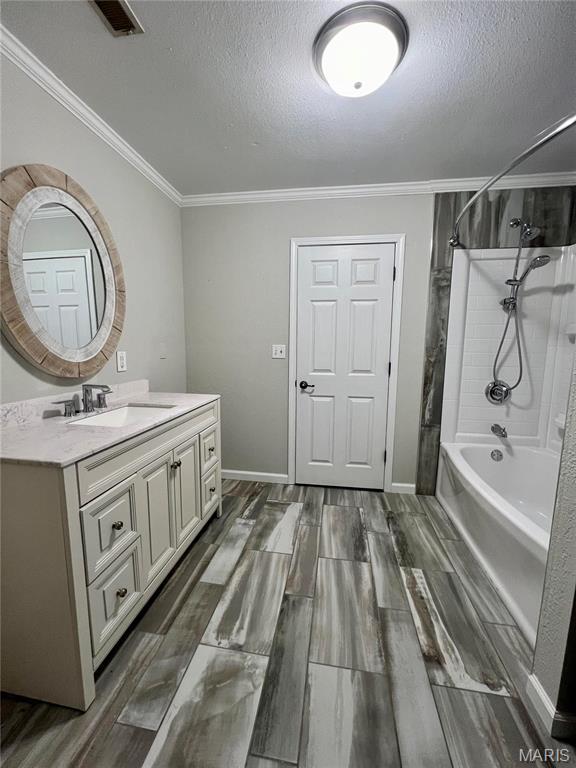 792 County Road 466, Poplar Bluff, MO 63901 - bathroom featuring a textured ceiling, vanity, crown molding, wood finished floors, and shower / washtub combination