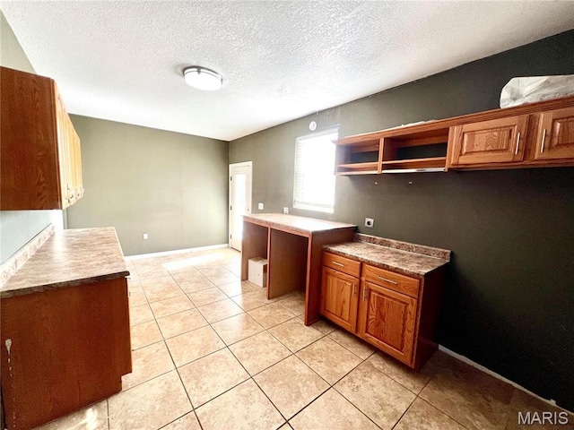 792 County Road 466, Poplar Bluff, MO 63901 - kitchen featuring open shelves, brown cabinetry, a textured ceiling, light tile patterned floors, and baseboards