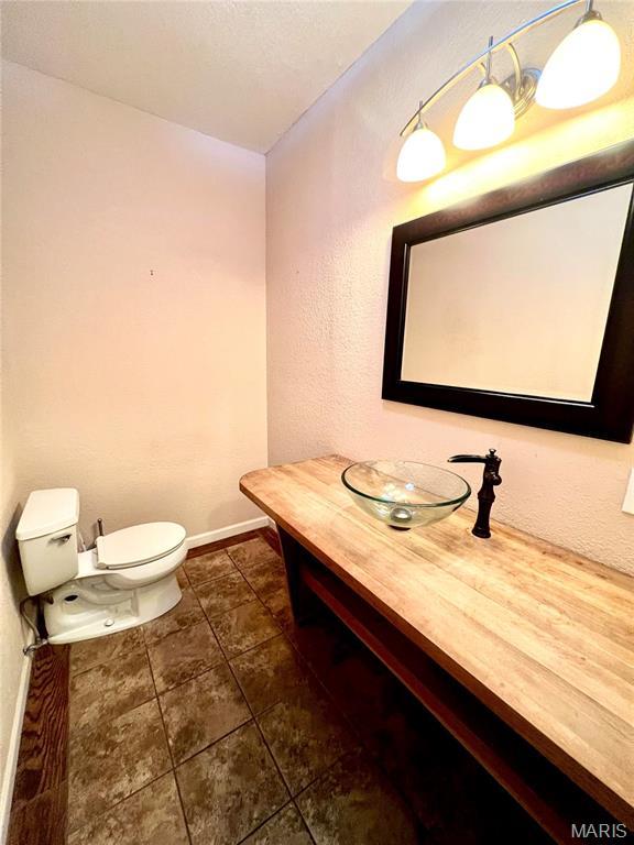 792 County Road 466, Poplar Bluff, MO 63901 - half bathroom with toilet, tile patterned floors, vanity, and baseboards