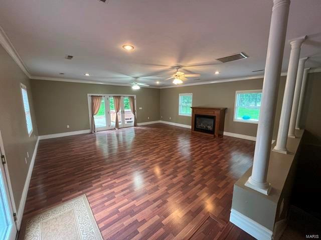 15800 State Highway Ad, Dexter, MO 63841 - unfurnished living room featuring decorative columns, crown molding, plenty of natural light, ceiling fan, and wood finished floors
