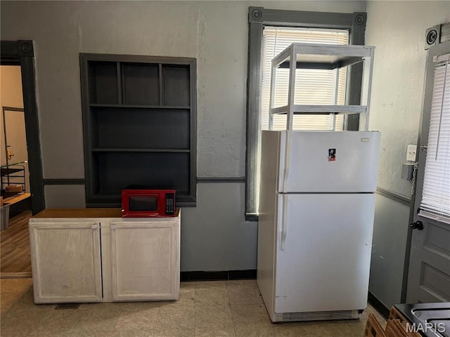 kitchen with freestanding refrigerator, healthy amount of natural light, and electric range