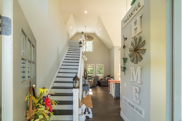 stairway with high vaulted ceiling, recessed lighting, wood finished floors, and a chandelier