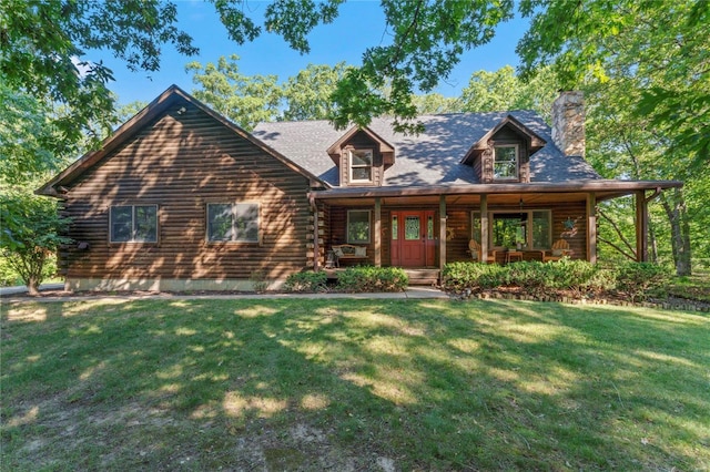 log cabin with log exterior, a chimney, a front lawn, and covered porch