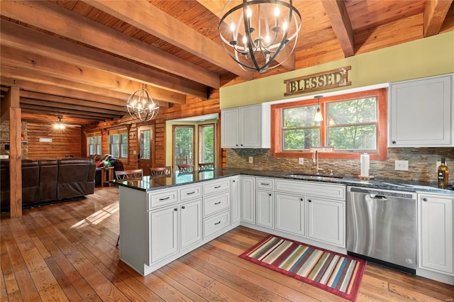 kitchen featuring stainless steel dishwasher, a chandelier, a sink, white cabinetry, and beam ceiling