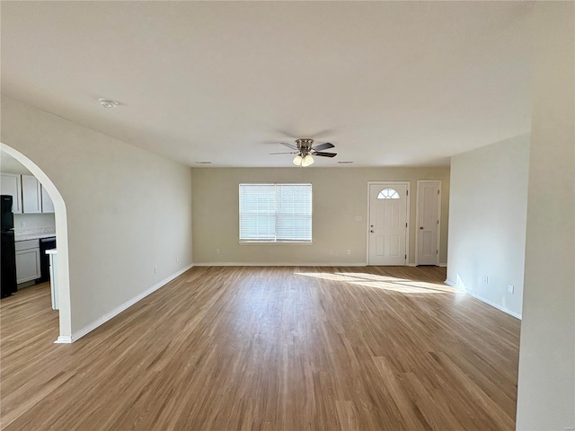 813 Breeze Ct, Perryville, MO 63775 - unfurnished living room featuring a ceiling fan, light wood finished floors, arched walkways, and baseboards