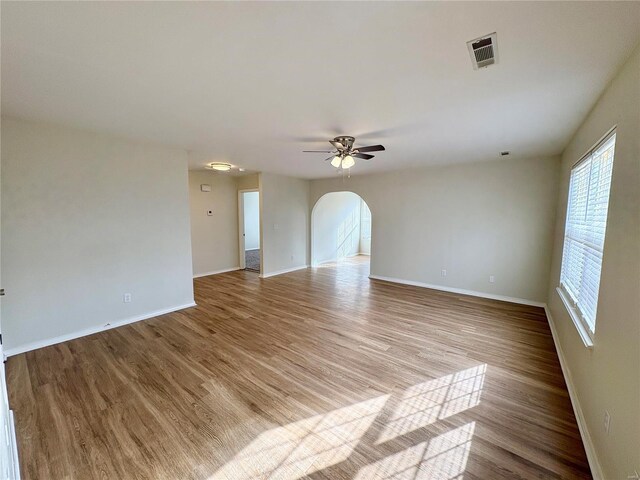 813 Breeze Ct, Perryville, MO 63775 - spare room featuring wood finished floors, baseboards, arched walkways, and a ceiling fan