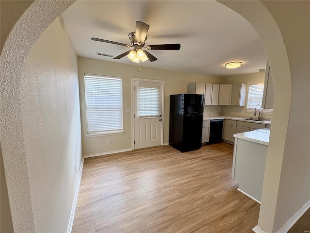 813 Breeze Ct, Perryville, MO 63775 - kitchen with black appliances, a sink, arched walkways, light wood-style floors, and light countertops