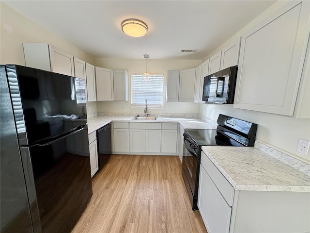 813 Breeze Ct, Perryville, MO 63775 - kitchen with black appliances, a sink, light wood finished floors, light countertops, and decorative light fixtures