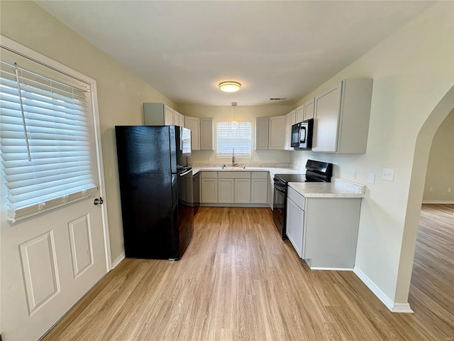 813 Breeze Ct, Perryville, MO 63775 - kitchen with black appliances, a sink, arched walkways, and light wood-style flooring