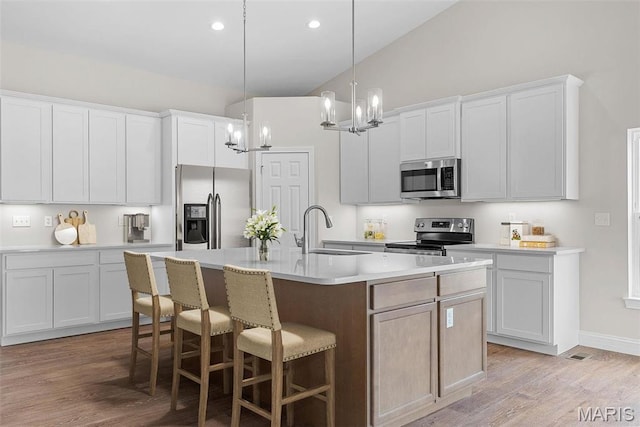 2995 Halls Green Dr, Washington, MO 63090 - kitchen featuring appliances with stainless steel finishes, a sink, a chandelier, a kitchen breakfast bar, and a center island with sink