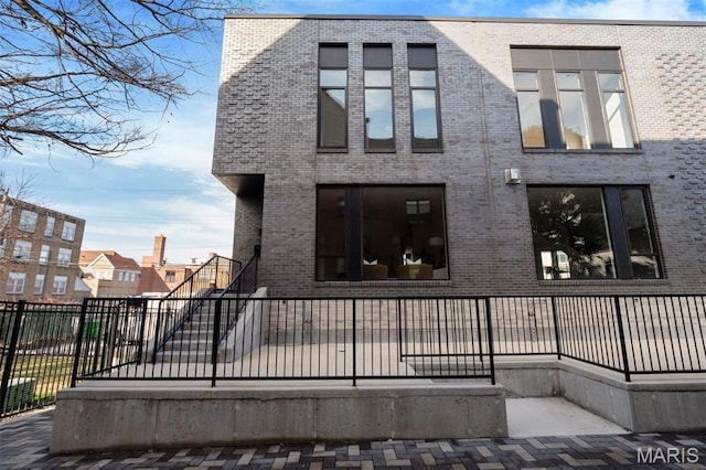 215 N Sarah St Unit 13, Saint Louis, MO 63108 - back of house with brick siding, fence, and stairs