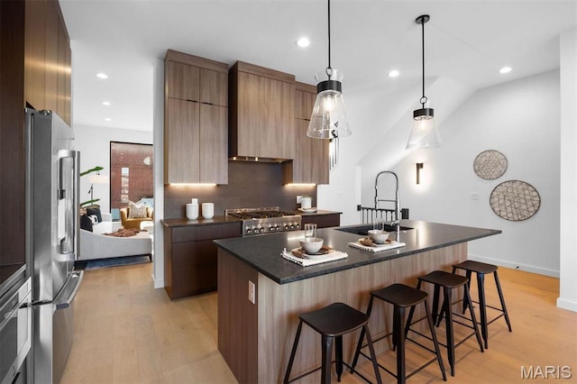 215 N Sarah St Unit 13, Saint Louis, MO 63108 - kitchen with a sink, modern cabinets, dark countertops, appliances with stainless steel finishes, and a breakfast bar