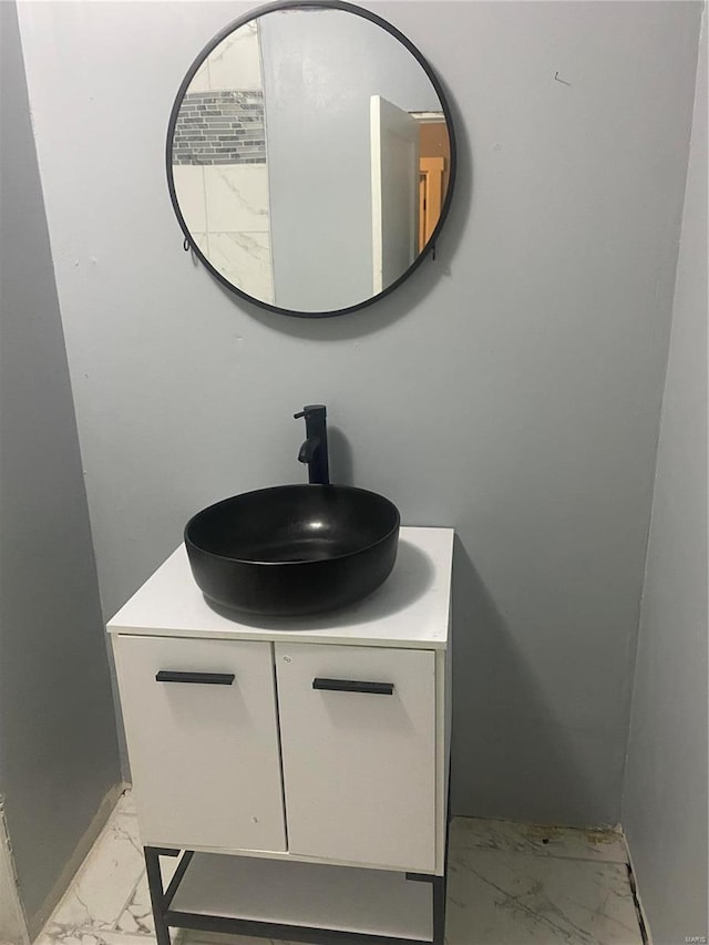 bathroom with marble finish floors and vanity