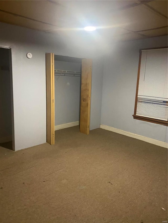 unfurnished bedroom featuring carpet flooring, a closet, and baseboards